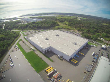 An aerial shot of Prologis Gothenburg DC1 surrounded by green landscape and water in the background